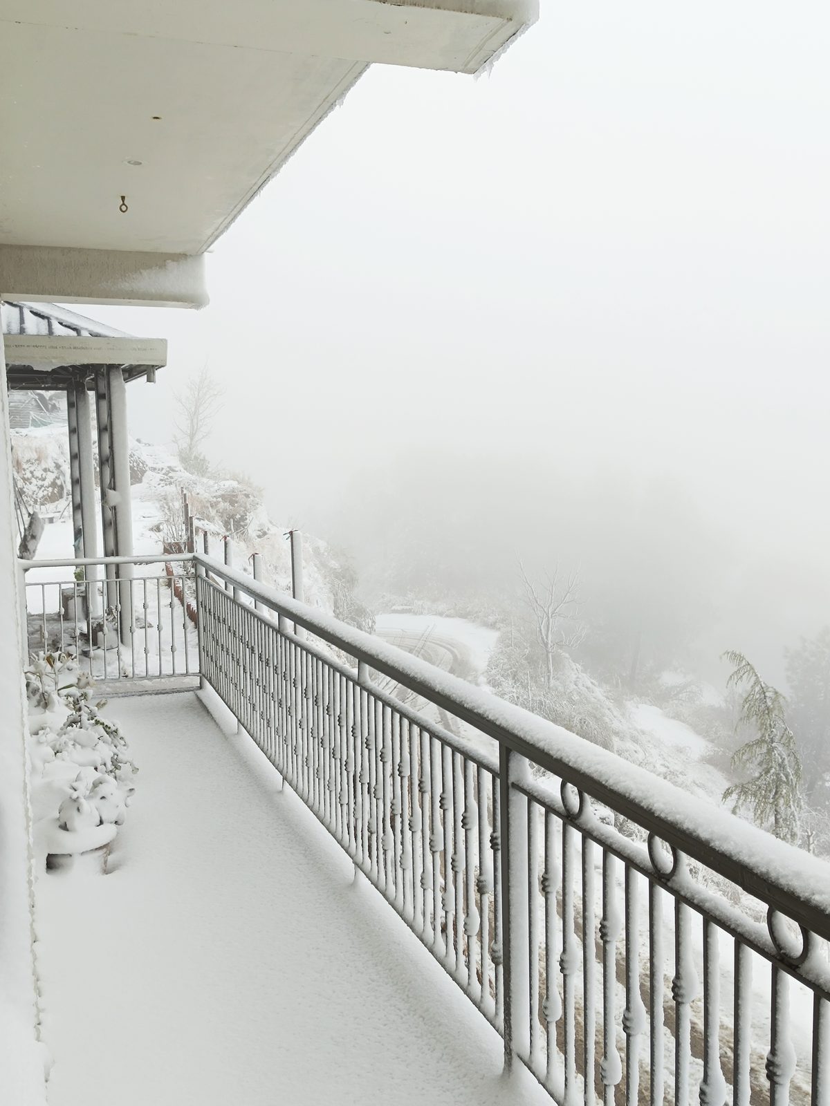 Fresh snow piled on the balcony railings the morning after a snowfall
