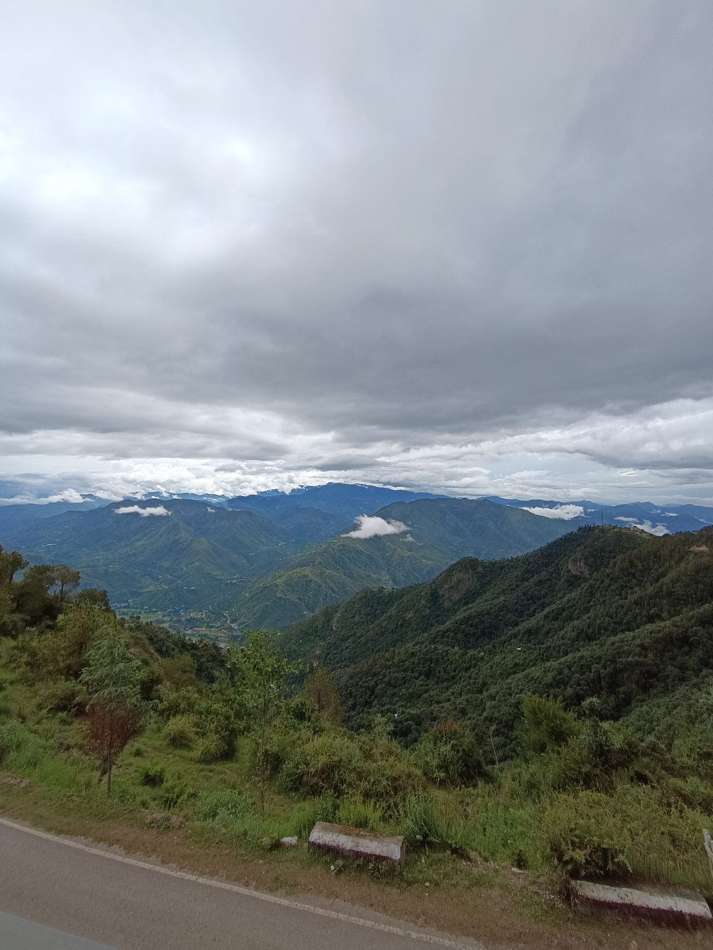 Monsoon view from the ridge — low clouds over the Himachal valley and green forested ridges