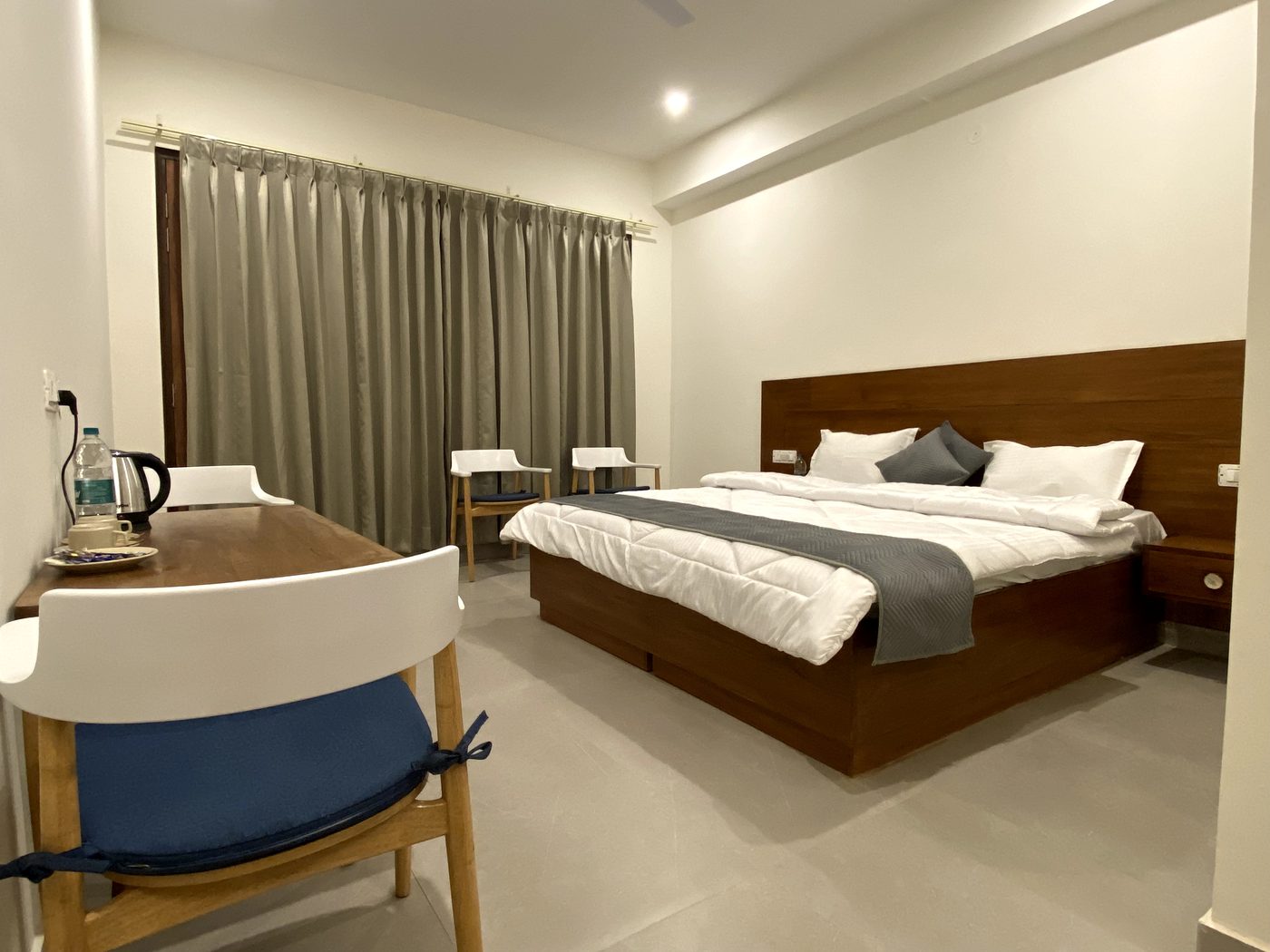 Deluxe room with king bed, writing desk and kettle setup in the evening